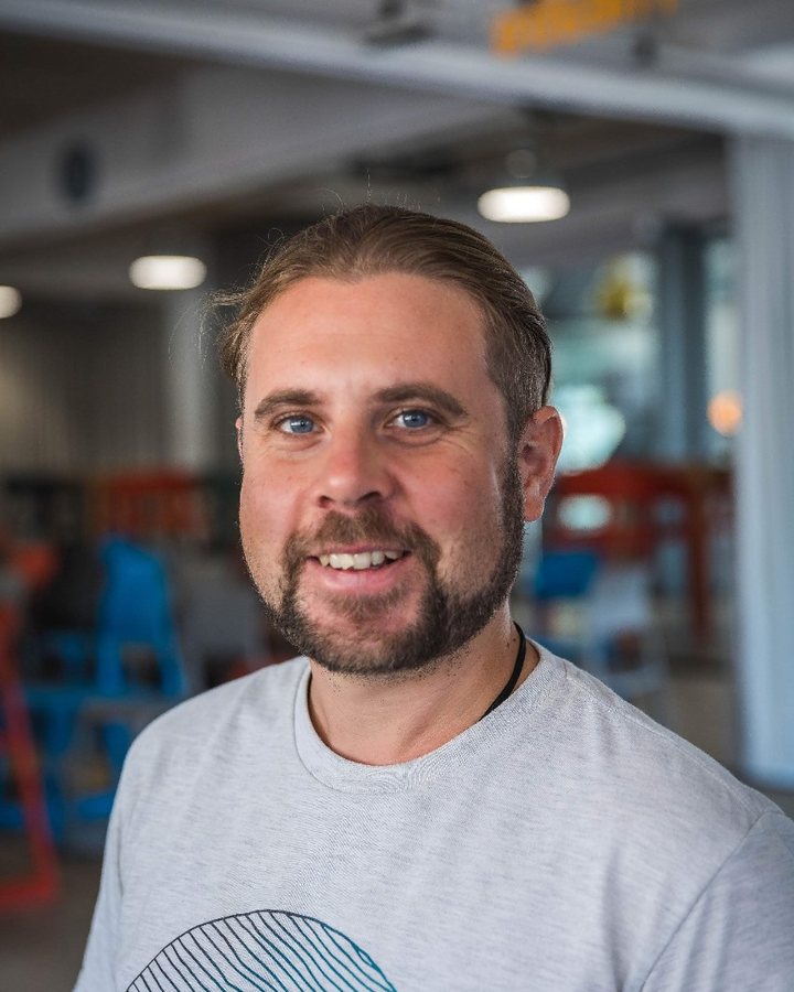 Abe Cambridge, smiling, in a grey T-shirt